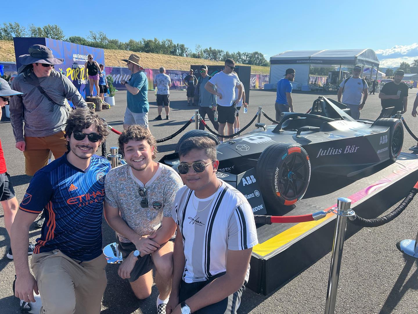 Jake with friends in front of a Formula E race car at Portland International Raceway